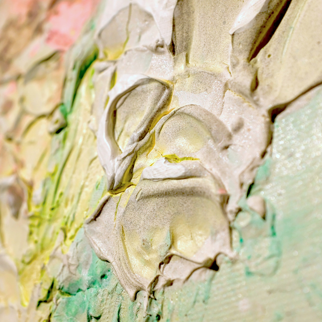 Sculptural abstract painting by Marina Aristotel, titled "In the garden". Features a tactile topography of pastel pink and soft green colors with white abstract floral textures. Floral details of the artwork.